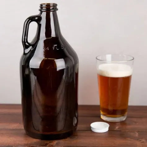 glass growler with beer poured next to it in a glass on wood bench