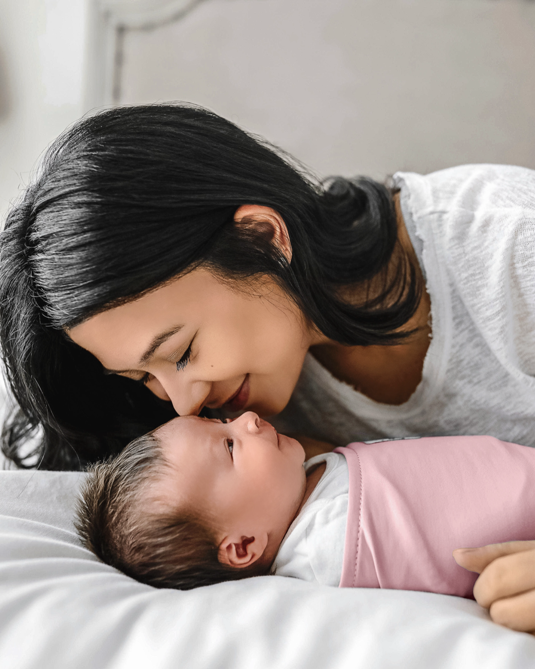 Mom with baby wrapped in a pink ollie world swaddle 