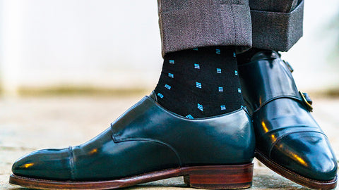 navy blue dress shoes with black and blue patterned dress socks and a grey suit