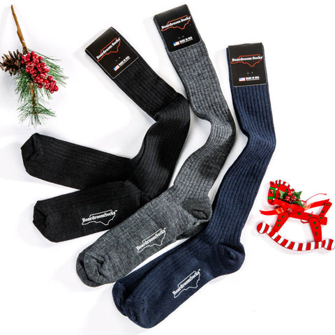 black grey and navy merino wool over the calf socks surrounded by holiday decor