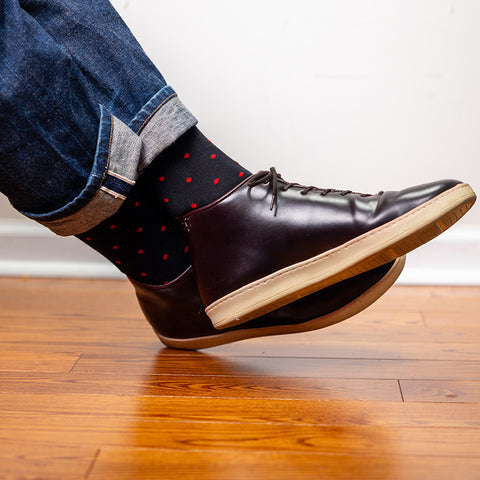 black dress socks with red dots paired with jeans and cordovan trainers