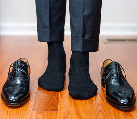 black oxfords paired with black dress socks and charcoal slacks