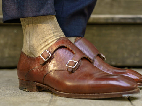 Selective closeup shot of a person wearing blue pants and brown shoes with  blue socks Stock Photo by wirestock