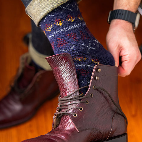 man wearing navy merino wool fair isle socks sliding on dress boots