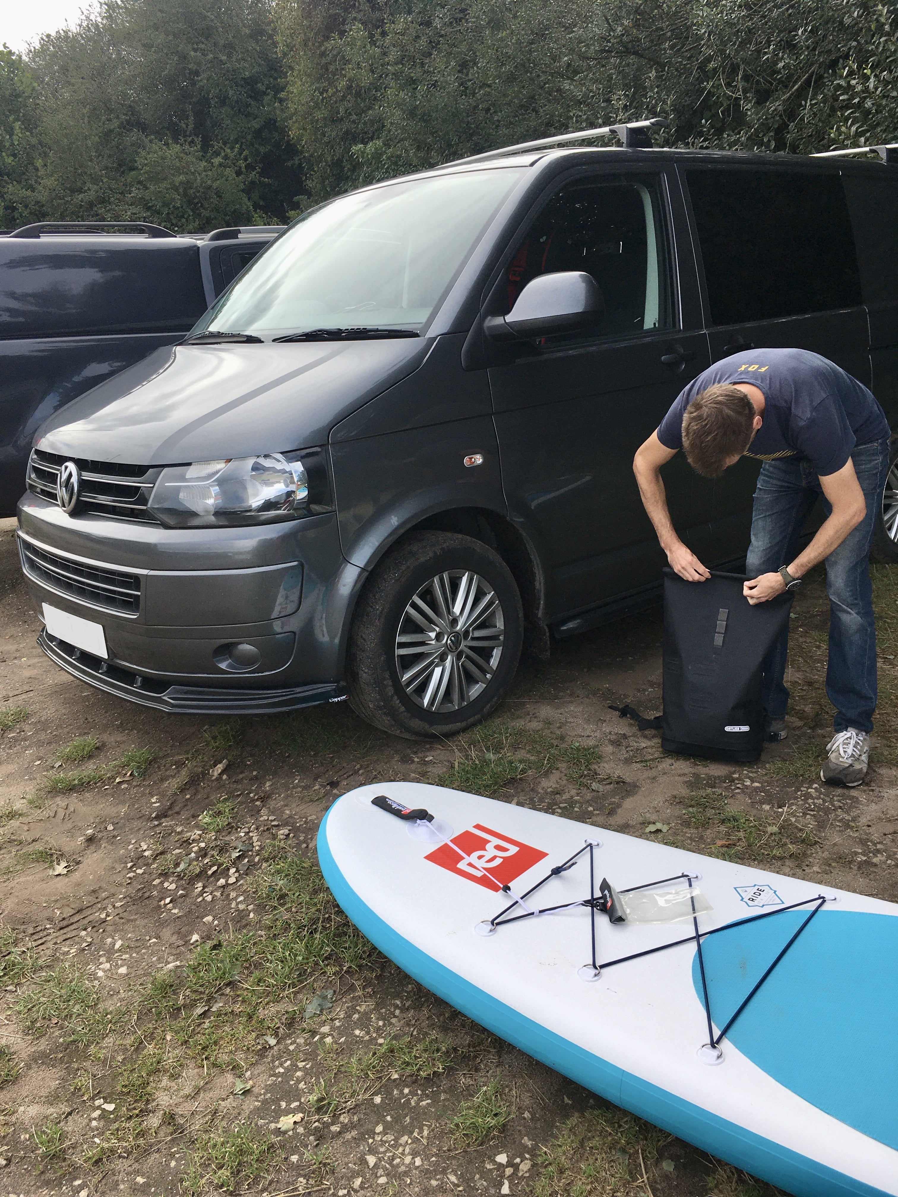 piggl campervan paddlebaording at red cliffe campsite in dorset