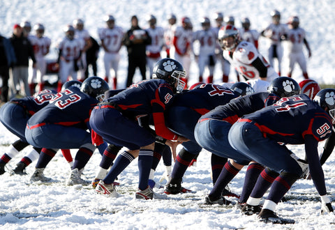 Football Team In Snow Paying Offensive and Defensive 