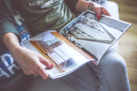 woman reading a magazine or catalog on interior design and architecture