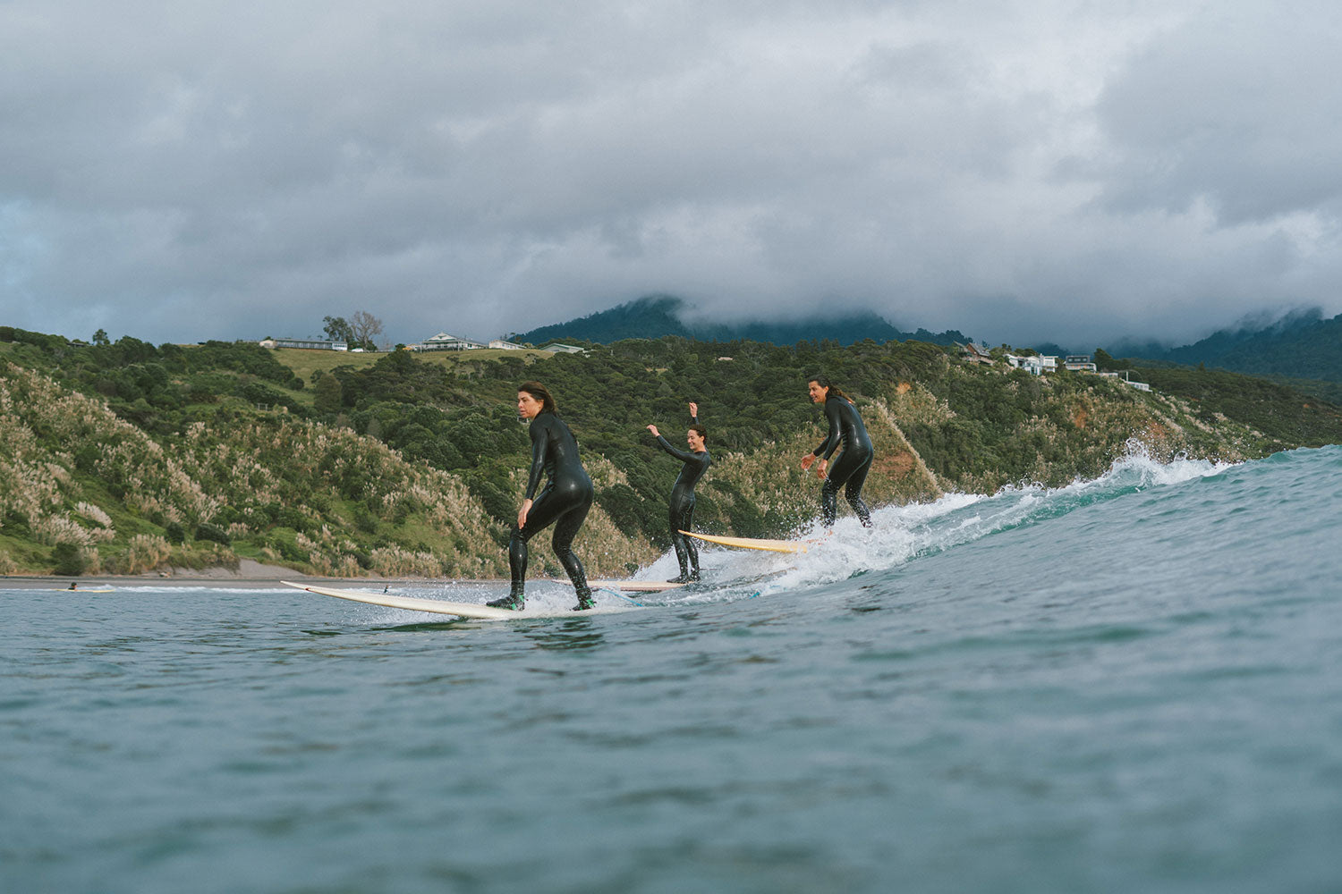 Mahsa, Ella and Eleanor surfing at Raglan