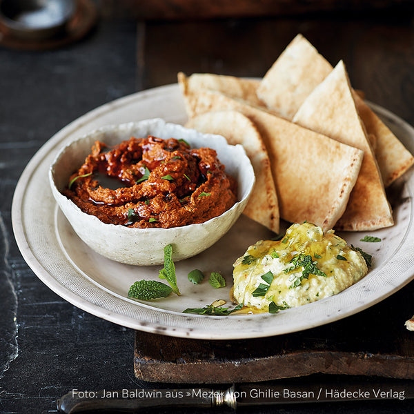 Paprika Dip mit Walnüssen, Fladenbrot und weiterem Feta-Dip auf orientalischer Tafel