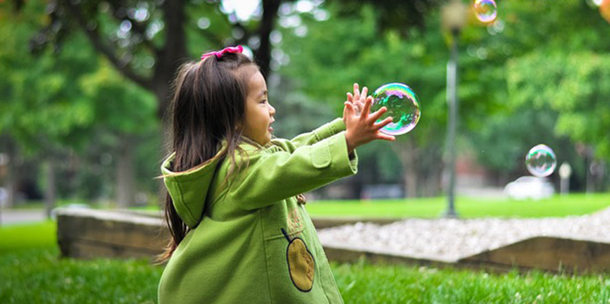 girl playing with bubbles