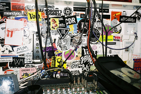 An image of a recording studio with a wall covered in stickers.