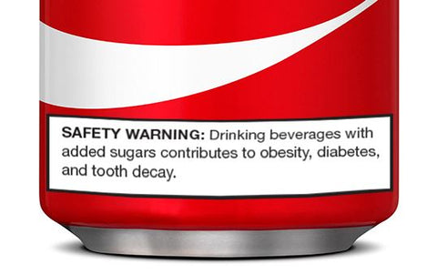 A can of soda with a warning label that cautions about risks of obesity and tooth decay.