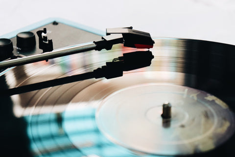 An image of a vinyl record with a record needle hovering just above.