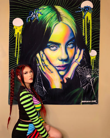 An image of the artist kneeling in front of one of her works, which depicts singer Billie Eilish in black and neon green hues.