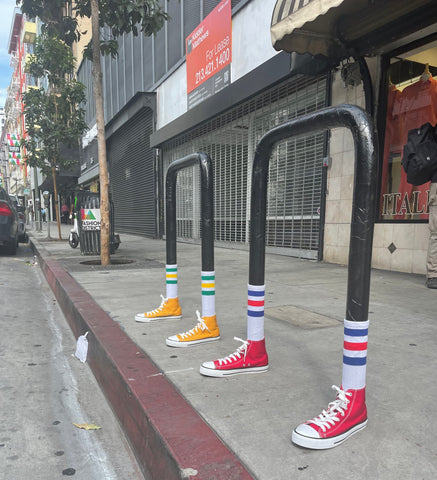 An image of bike racks that have had converse sneakers and striped socks added to the base.