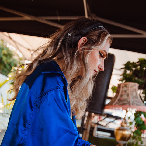 An image of Vancouver DJ Unmarried Woman in a blue shirt with flowing blonde hair.