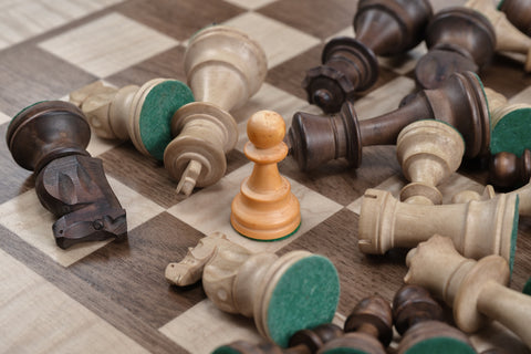 An image of a chessboard with the pieces scattered around, some overturned.