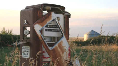 An image of a rusty old gas pump in a field.