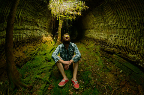 A photo of a man sitting in front of a tree.