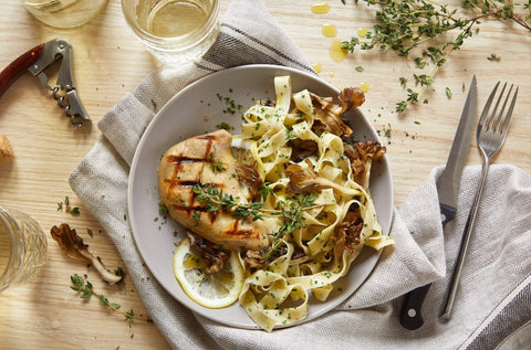 A plate of pasta with a lab-grown chicken breast in the middle.