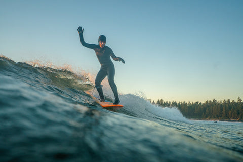 An image of Emily Ballard riding her surfboard across a wave.