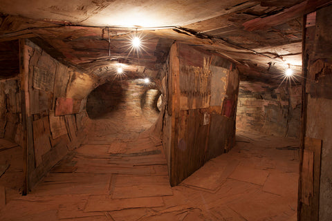An image of an art installation of what looks like an underground cave made of wood.