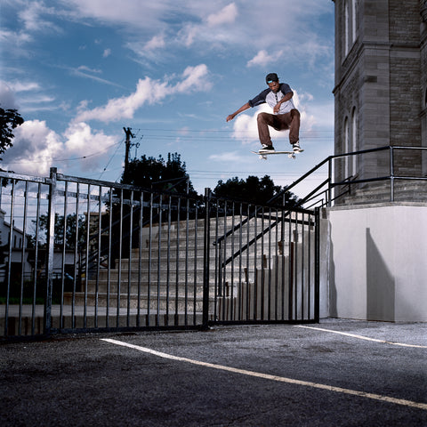An instagram square image of a skateboarder leaping through the air, high above the rail of a staircase.