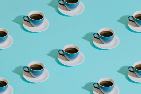 An image featuring 10 identical cups of coffee evenly spaced and dotted along a light blue background.