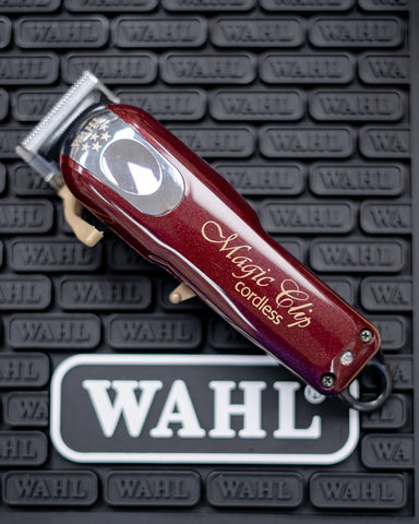 A Wahl Magic Clip Cordless Clipper on a Wahl brand barber station mat.