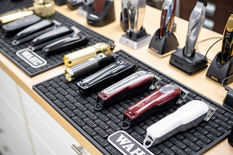 A table full of professional barber clippers from BaByliss Pro, Andis, Wahl, Stylecraft, and Oster.