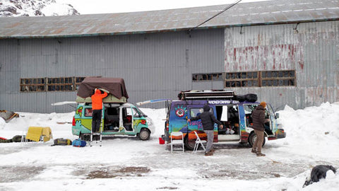 two camper vans setting up camp in the snow