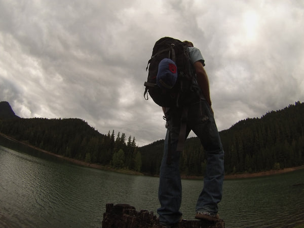 Man standing on a log by a river