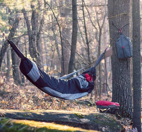 sleeping bag hammock hung between two trees