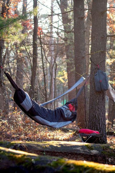 sleeping bag hammock hung between two trees