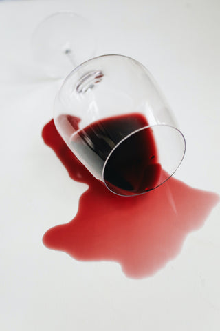 A spilled red wine in a long stemmed wine glass