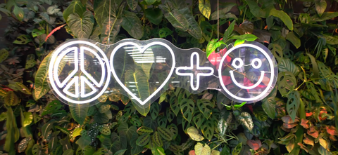 Peace Love and Happiness Club icon neon sign in front of the living wall in store