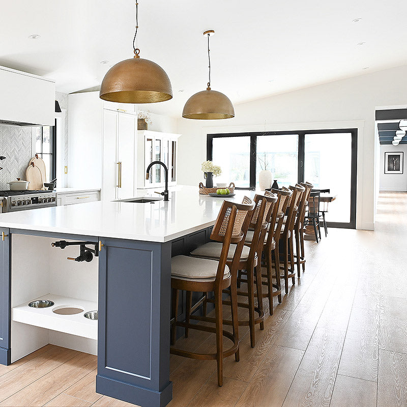 Large 14 foot custom kitchen island with an integrated feeding station for a family's dogs