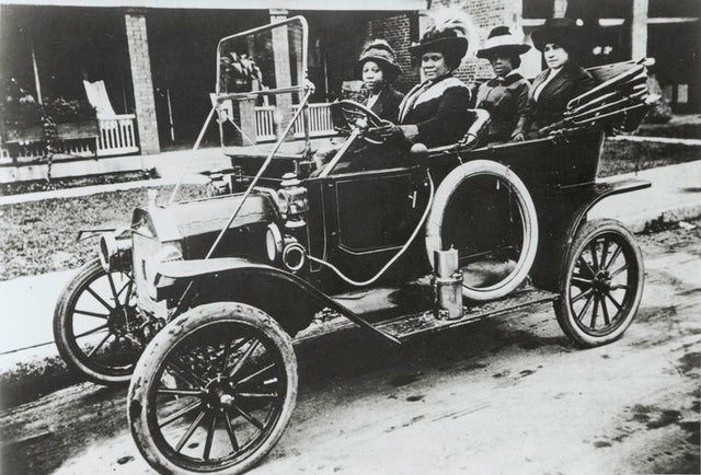 madame c j walker, an african american woman, driving an early model convertible car with the top down