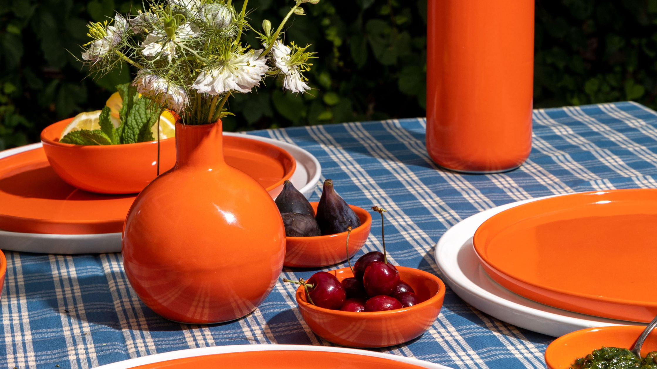 Brightly colored handmade pottery set on a summer table.
