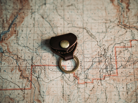 genuine-leather-guitar-pic-keychain-sitting-on-an-old-map-golden-age-supply-company