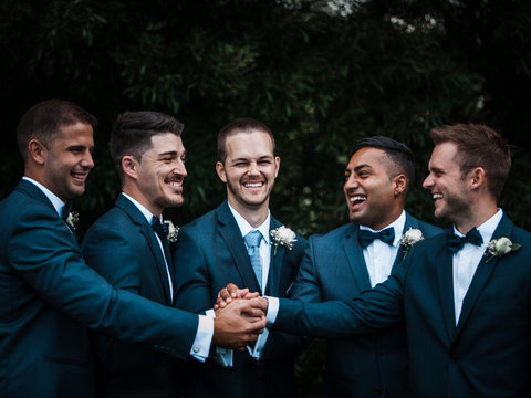 groom-and-groomsmen-dressed-in-navy-suits-pose-for-the-camera