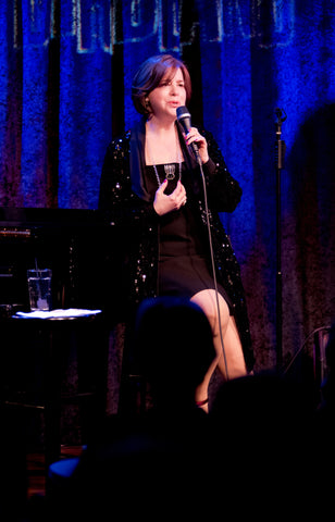 Celia Berk performing in a black dress and Icon Style jewelry