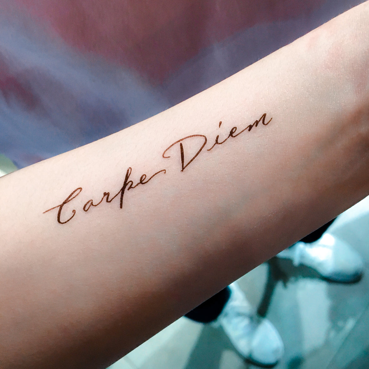 Carpe diem lettering tattoo located on the inner