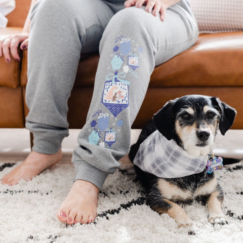 Woman in Chanukah Lounge Pants with Dog Brindle Market Woman With Brindle Market Pawlidays Sherpa Fleece Blanket Gifts That Give Back The Ultimate Pet Parent Holiday Gift Guide