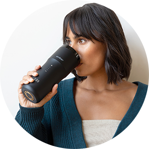 Young woman drinking from Ember Travel Mug²