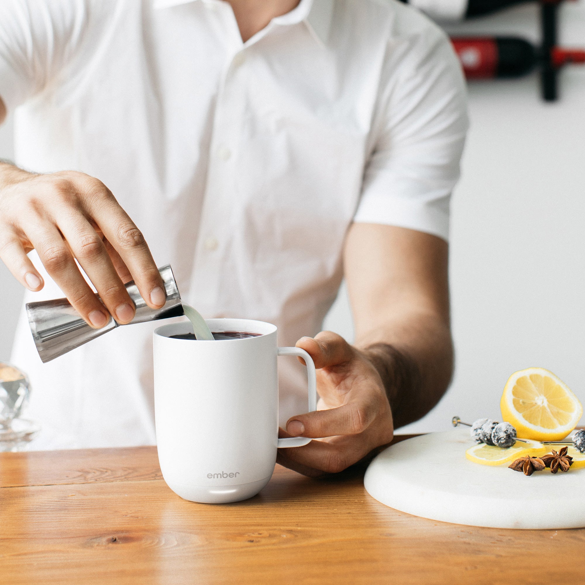 A man fills an Ember Mug² with 1 ounce of lemon juice.