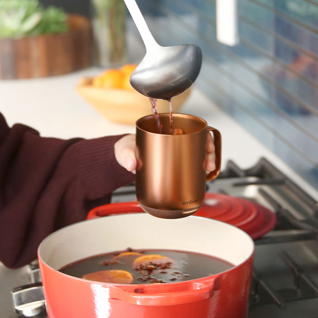 A person ladles warm mulled wine into a Copper Ember Mug².