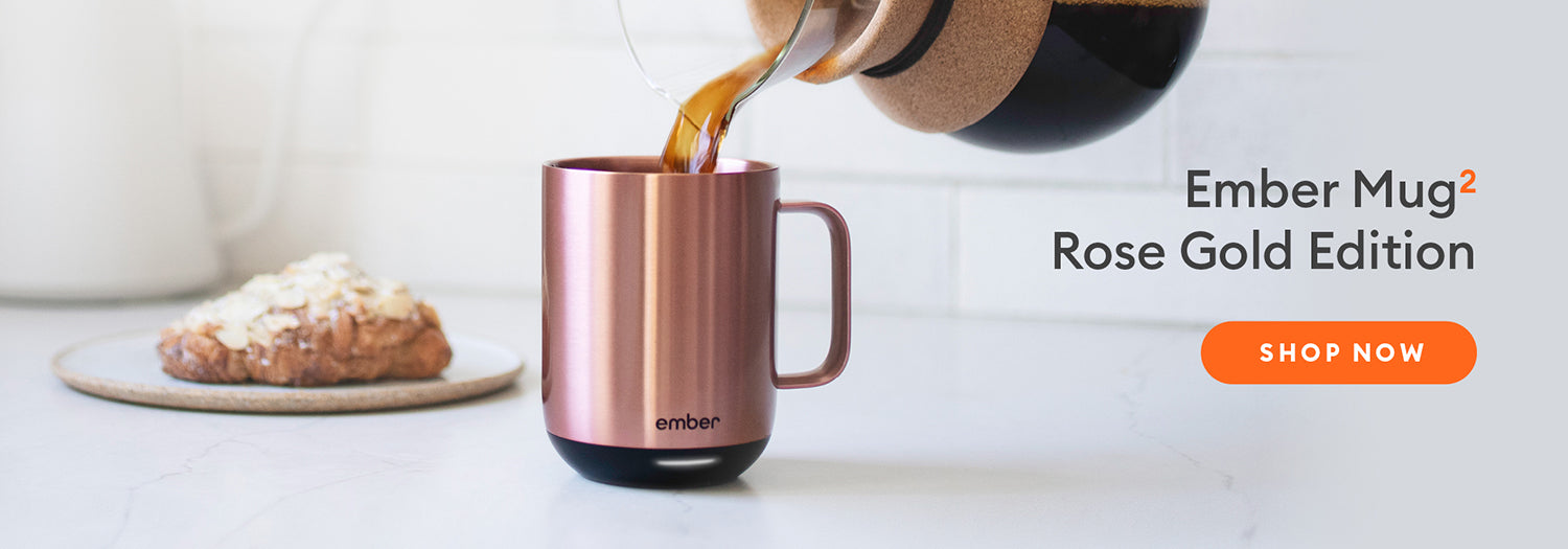 Rose Gold Ember Mug 2 rests on kitchen counter next to a croissant. Shop Now.