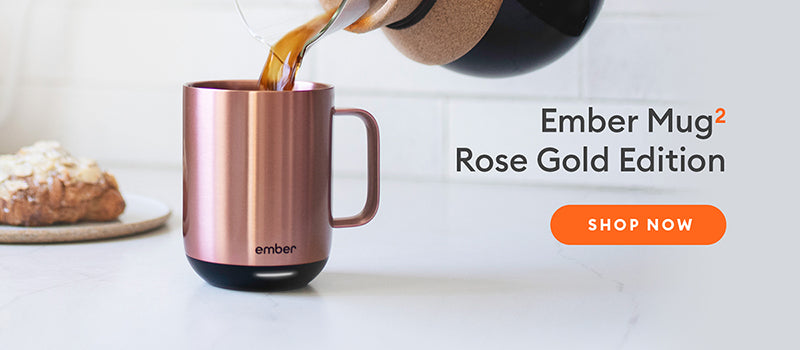 Rose Gold Ember Mug 2 rests on kitchen counter next to a croissant. Shop Now.