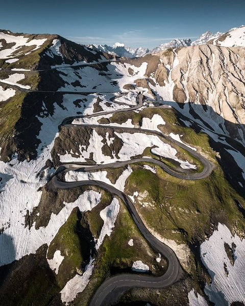 Image with mountains, meadows, nature, twisting roads, snow